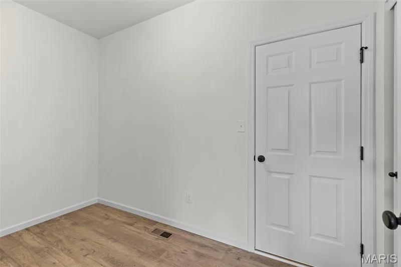 Empty room featuring wood finished floors and baseboards — 563 Edison Way, Wentzville, MO 63385