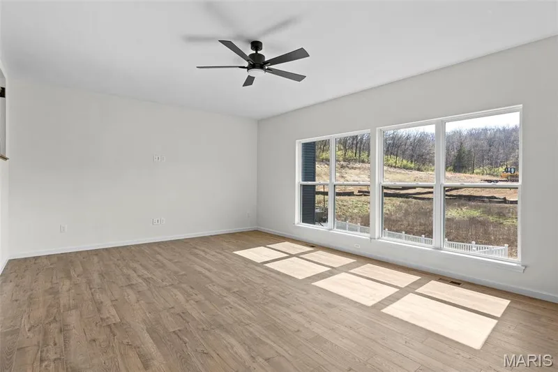 Empty room with light wood-type flooring and ceiling fan — 563 Edison Way, Wentzville, MO 63385