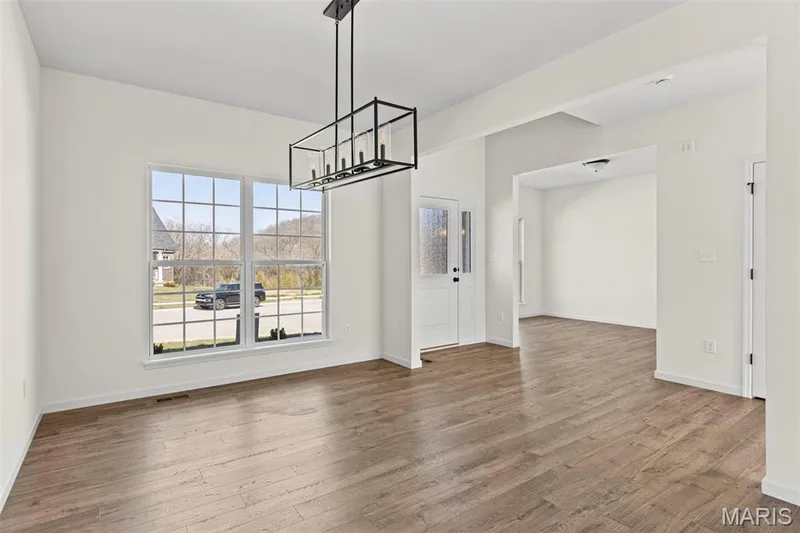 Unfurnished dining area featuring light wood-style floors and a chandelier — 563 Edison Way, Wentzville, MO 63385