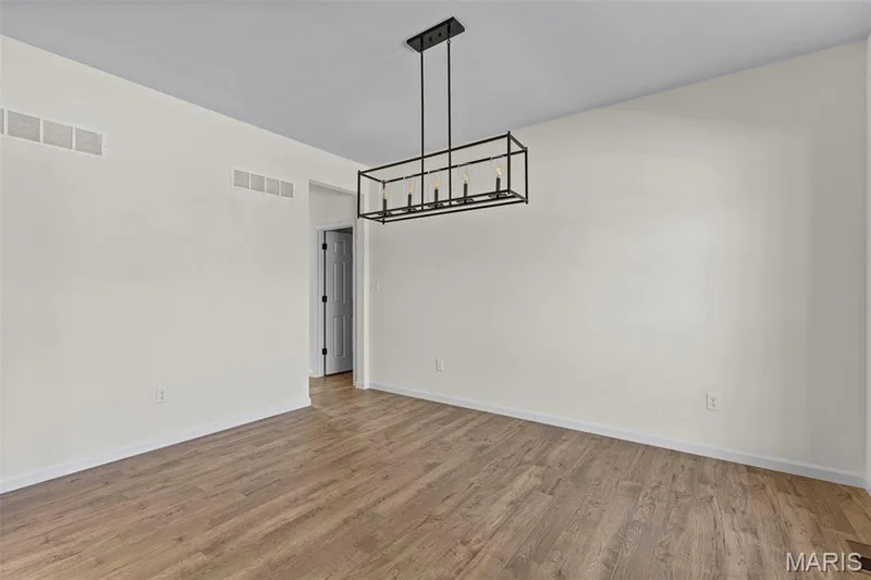 Unfurnished dining area with wood finished floors and a chandelier — 563 Edison Way, Wentzville, MO 63385
