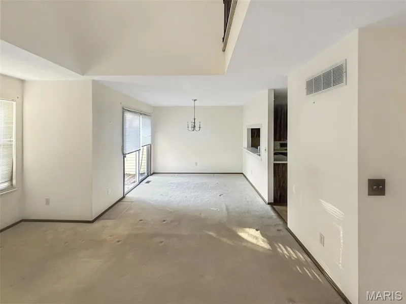 Spare room featuring a chandelier and baseboards — 312 Crown Colony Court #F, St Peters, MO 63376