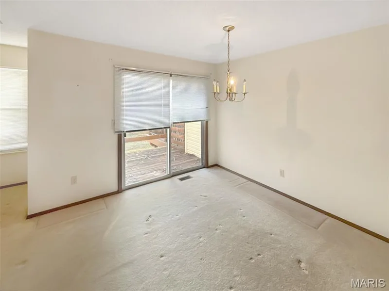 Unfurnished dining area with a chandelier and light carpet — 312 Crown Colony Court #F, St Peters, MO 63376