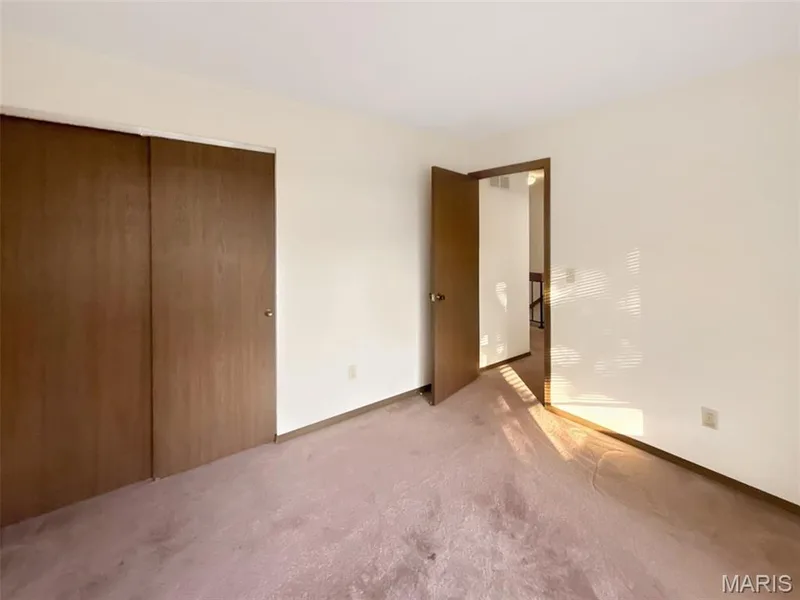 Unfurnished bedroom featuring carpet flooring and a closet — 312 Crown Colony Court #F, St Peters, MO 63376