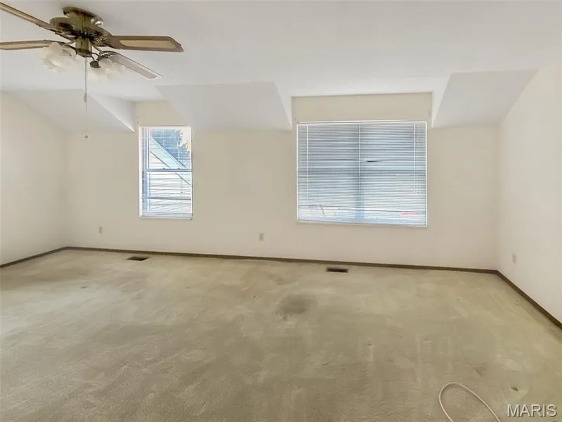 Empty room featuring light colored carpet and ceiling fan — 312 Crown Colony Court #F, St Peters, MO 63376