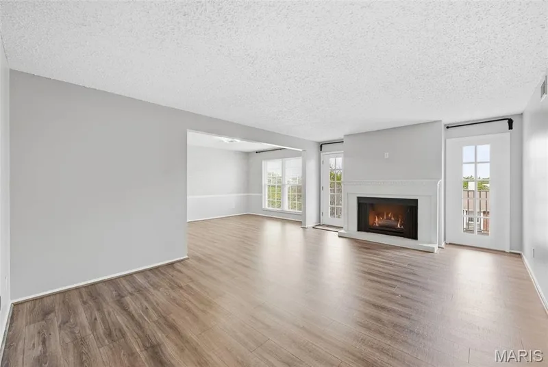 Wood-finish flooring, white fireplace with mantle, and two sets of French doors — 14443 Bantry Lane #16, Chesterfield, MO 63017