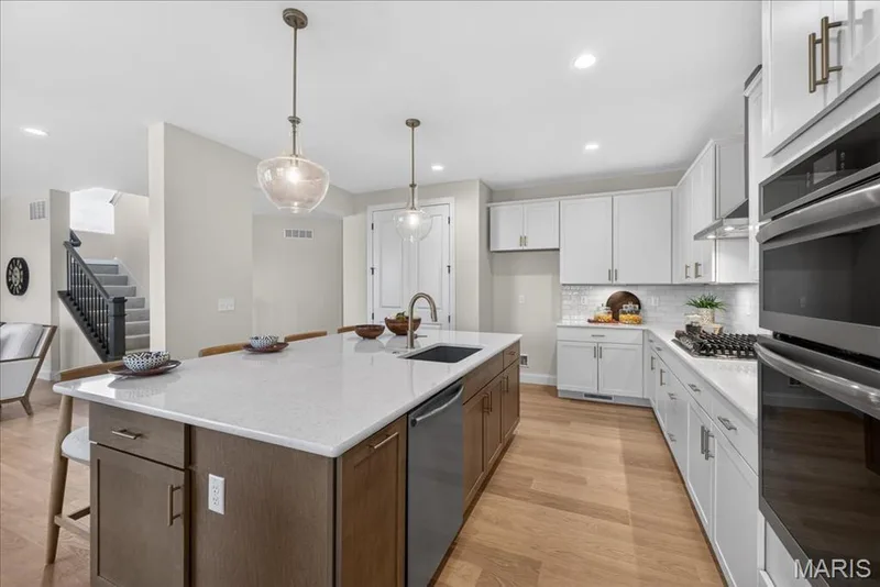 Kitchen with built-in stainless steel gas appliances, custom cabinets and Quartz countertops — 125 Sterling Drive, Lake St. Louis, MO 63367