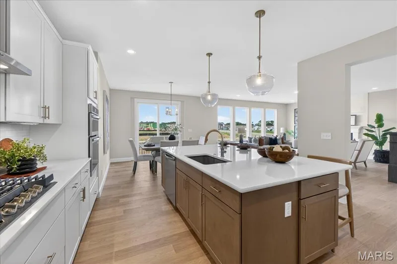 Kitchen with built-in stainless steel gas appliances, custom cabinets and Quartz countertops — 125 Sterling Drive, Lake St. Louis, MO 63367