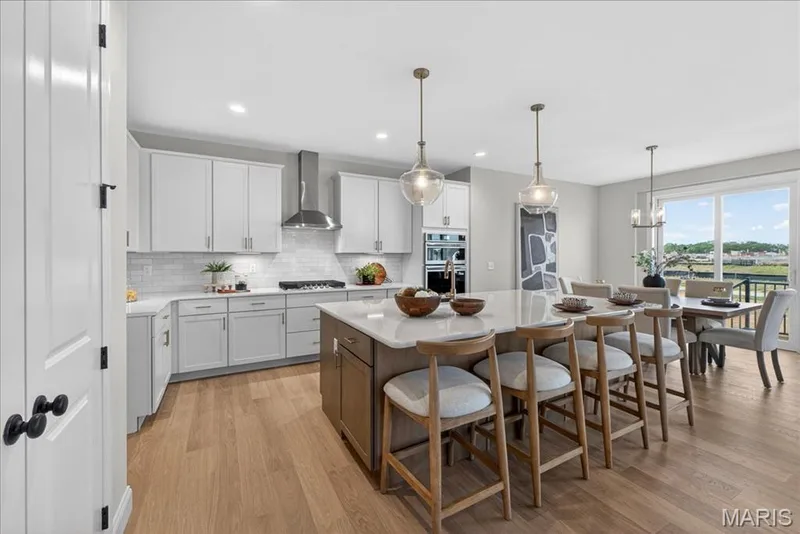 Kitchen with built-in stainless steel gas appliances, custom cabinets and Quartz countertops — 125 Sterling Drive, Lake St. Louis, MO 63367