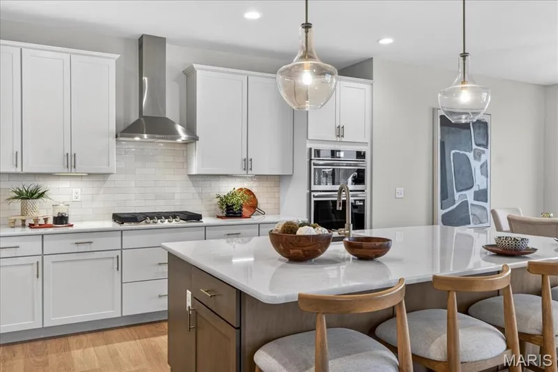 Kitchen with built-in stainless steel gas appliances, custom cabinets and Quartz countertops — 125 Sterling Drive, Lake St. Louis, MO 63367
