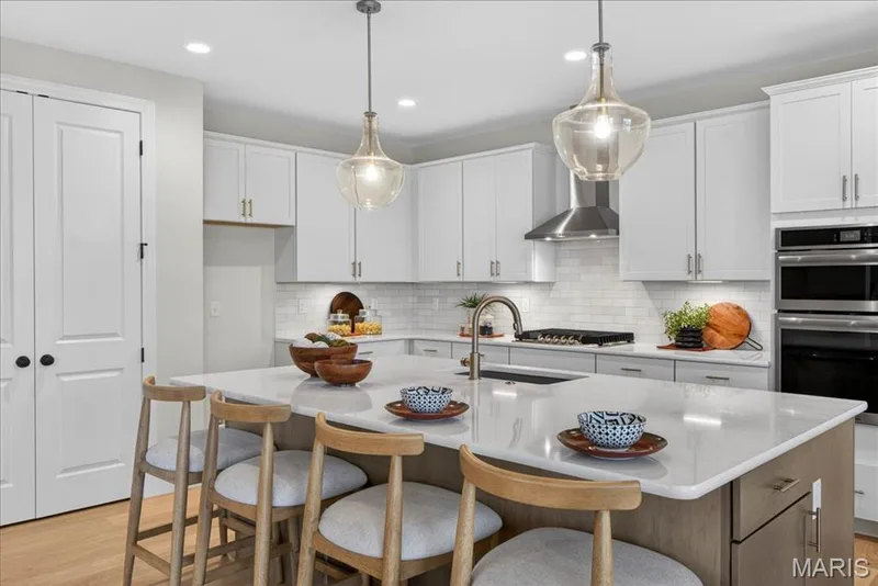 Kitchen with built-in stainless steel gas appliances, custom cabinets and Quartz countertops — 125 Sterling Drive, Lake St. Louis, MO 63367