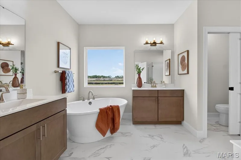 Primary bathroom with separate tub and shower, split vanity, double bowls — 125 Sterling Drive, Lake St. Louis, MO 63367
