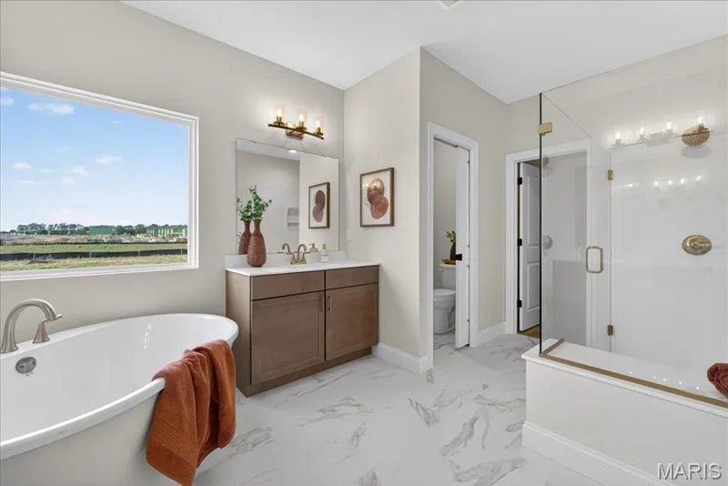 Primary bathroom with separate tub and shower, split vanity, double bowls — 125 Sterling Drive, Lake St. Louis, MO 63367