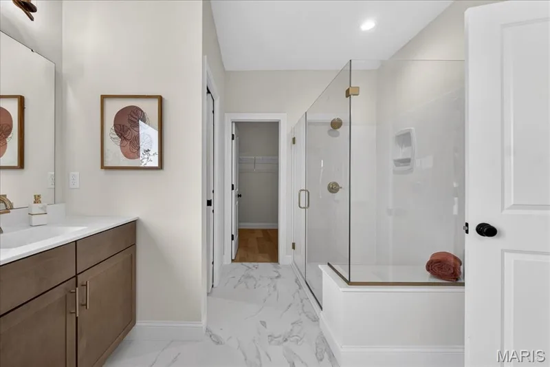 Primary bathroom with separate tub and shower, split vanity, double bowls — 125 Sterling Drive, Lake St. Louis, MO 63367