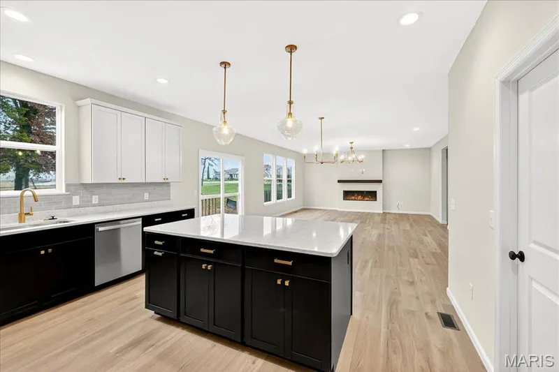 Kitchen featuring dark cabinets, pendant lighting, light wood-style floors, backsplash, and recessed lighting — 210 Randlin Drive, O'Fallon, MO 63367