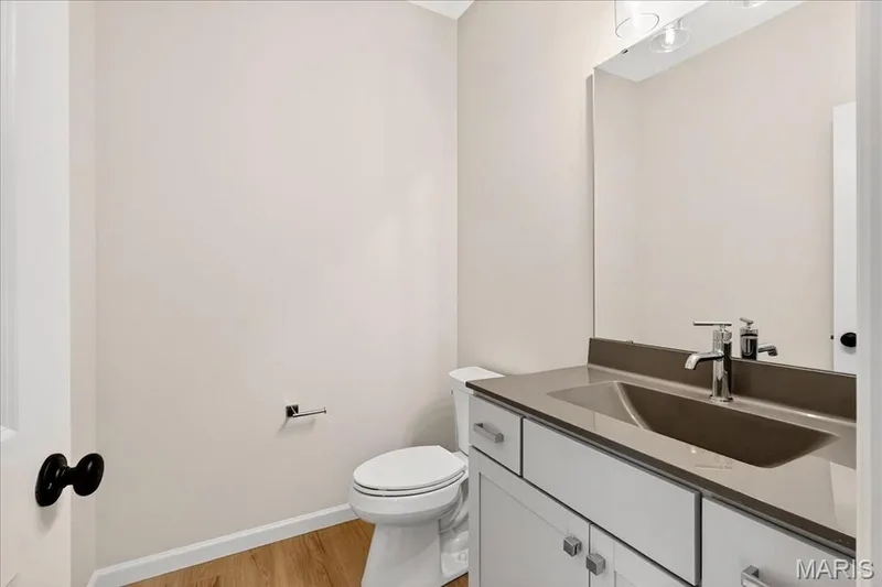 Half bath featuring vanity and light wood-style floors — 210 Randlin Drive, O'Fallon, MO 63367