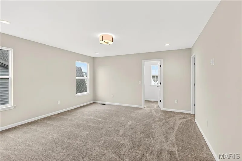Primary bedroom with light carpet and recessed lighting and walk-in closet — 210 Randlin Drive, O'Fallon, MO 63367