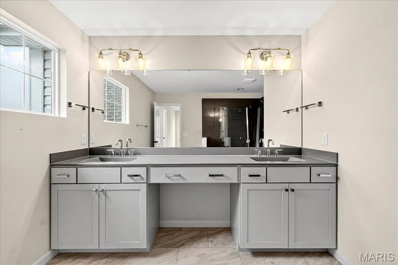 Primary Bathroom featuring double vanity and baseboards — 210 Randlin Drive, O'Fallon, MO 63367