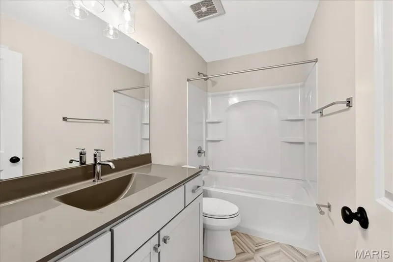 Bathroom with washtub / shower combination, vanity, and light floors — 210 Randlin Drive, O'Fallon, MO 63367