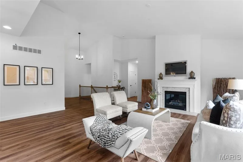 Living area featuring high vaulted ceiling, dark wood finished floors, a high end fireplace, and a chandelier — 1 TBB Rochester @ Kreder Farms, St Charles, MO 63304