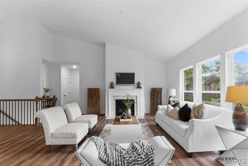 Living area with wood finished floors, high vaulted ceiling, and a premium fireplace — 1 TBB Rochester @ Kreder Farms, St Charles, MO 63304