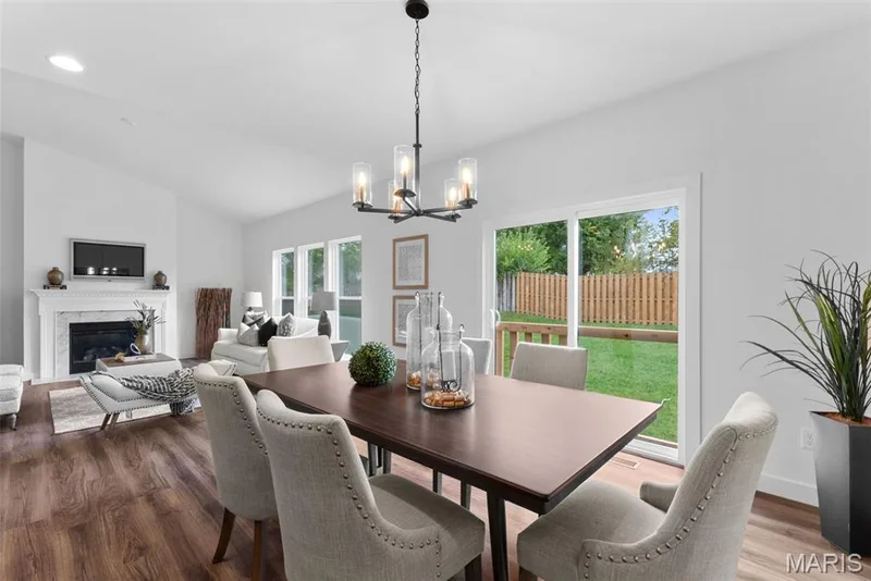 Dining space with vaulted ceiling, a premium fireplace, dark wood-style flooring, a chandelier, and recessed lighting — 1 TBB Rochester @ Kreder Farms, St Charles, MO 63304