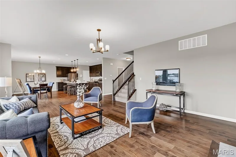 Living area with stairway, a chandelier, dark wood-type flooring, and recessed lighting — 1 TBB Sienna @ Kreder Farms, St Charles, MO 63304
