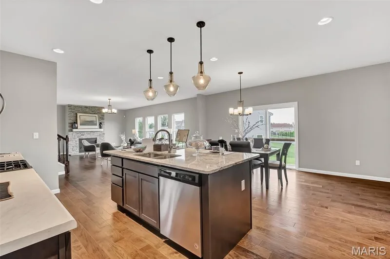 Kitchen with a chandelier, open floor plan, stainless steel dishwasher, an island with sink, and recessed lighting — 1 TBB Sienna @ Kreder Farms, St Charles, MO 63304