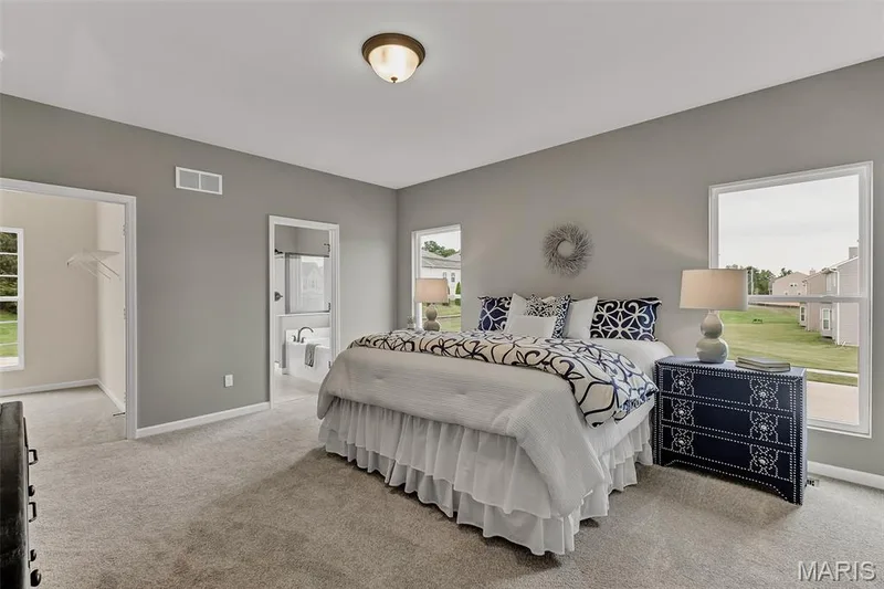 Bedroom featuring light carpet, a walk in closet, and ensuite bath — 1 TBB Sienna @ Kreder Farms, St Charles, MO 63304
