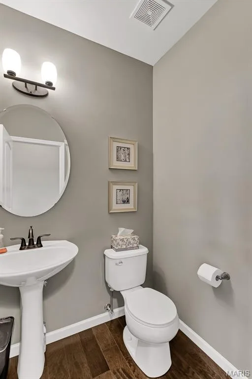 Bathroom featuring dark wood-style floors and baseboards — 1 TBB Sienna @ Kreder Farms, St Charles, MO 63304