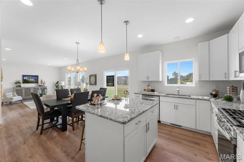 Kitchen featuring white cabinets, light stone counters, open floor plan, a kitchen island, and recessed lighting — 1 TBB Barkley @ Kreder Farms, St Charles, MO 63304