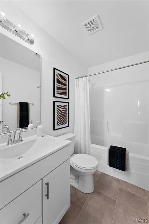 Bathroom featuring vanity, shower / bathtub combination with curtain, and dark tile patterned flooring — 1 TBB Barkley @ Kreder Farms, St Charles, MO 63304