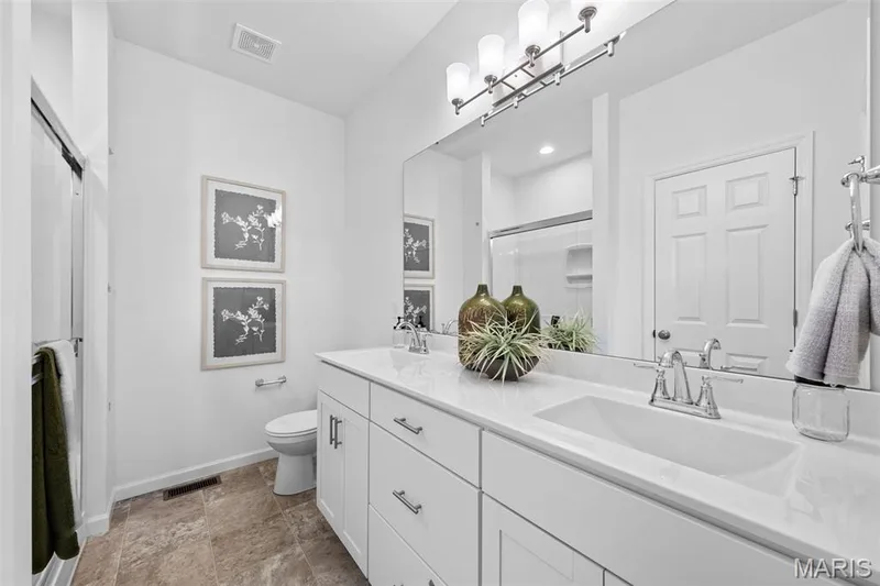 Bathroom with a stall shower, double vanity, and light stone finish floors — 1 TBB Westbrook @ Kreder Farms, St Charles, MO 63304