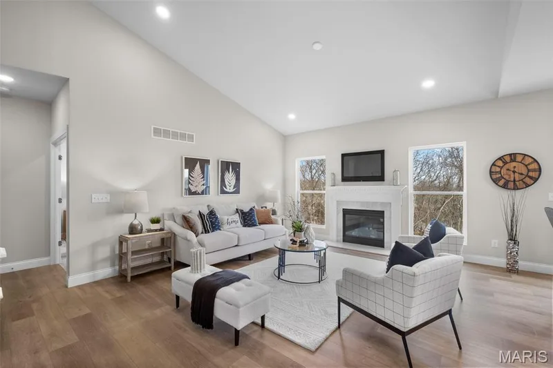 Living area featuring wood finished floors, a glass covered fireplace, recessed lighting, and high vaulted ceiling — 1 TBB Rockport @ Kreder Farms, St Charles, MO 63304