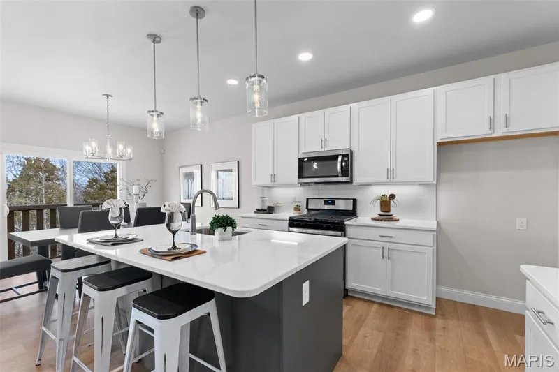 Kitchen featuring white cabinetry, pendant lighting, light wood finished floors, appliances with stainless steel finishes, and recessed lighting — 1 TBB Rockport @ Kreder Farms, St Charles, MO 63304
