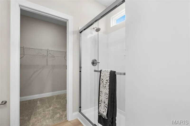 Full bath featuring a walk in closet, a shower stall, and light carpet — 1 TBB Rockport @ Kreder Farms, St Charles, MO 63304