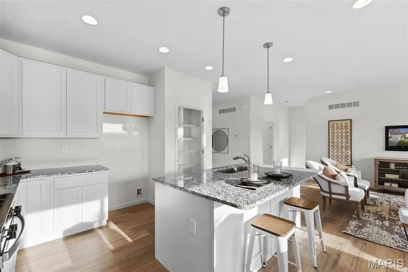 Kitchen featuring light stone counters, a kitchen breakfast bar, recessed lighting, open floor plan, and hanging light fixtures — 1 TBB Savoy @ Kreder Farms, St Charles, MO 63304