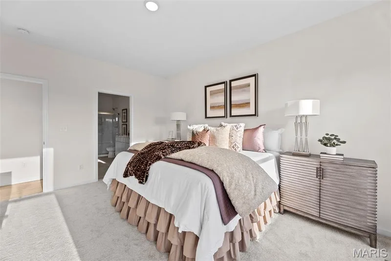 Carpeted bedroom featuring baseboards and ensuite bath — 1 TBB Savoy @ Kreder Farms, St Charles, MO 63304