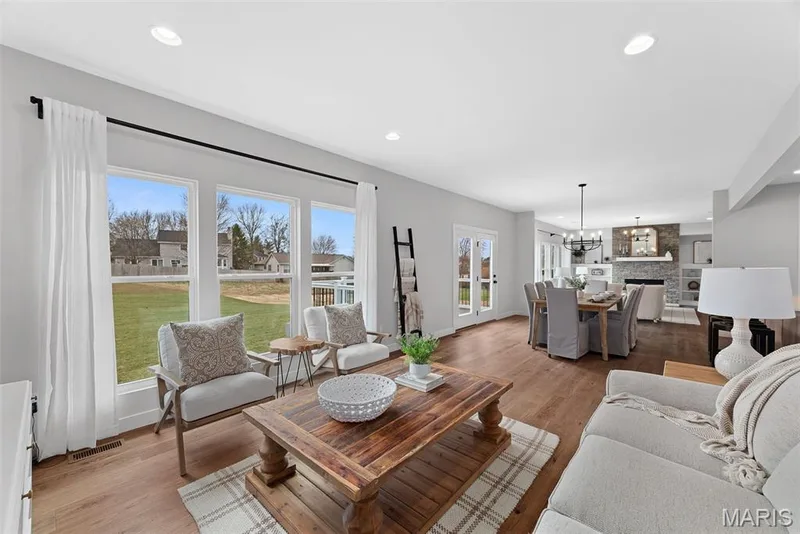 Living room featuring light wood-style floors, recessed lighting, a chandelier, and a fireplace — 1 TBB Bridgeport @ Kreder Farms, St Charles, MO 63304