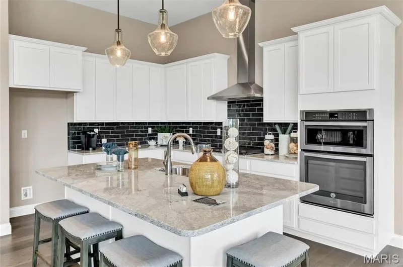 Kitchen with backsplash, dark wood-type flooring, and white cabinets — 1 TBB Monaco @ Kreder Farms, St Charles, MO 63304
