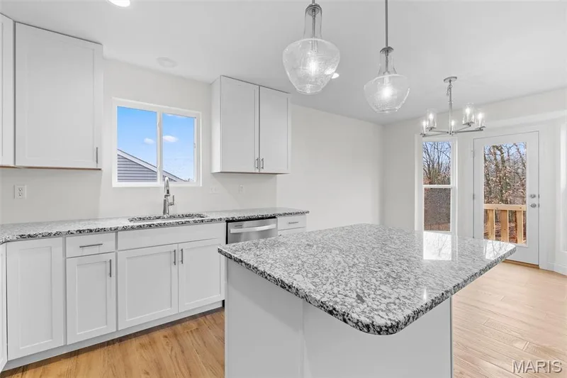 Kitchen featuring white cabinetry, light stone countertops, light wood-type flooring, and recessed lighting — 1 TBB Sydney @ Kreder Farms, St Charles, MO 63304