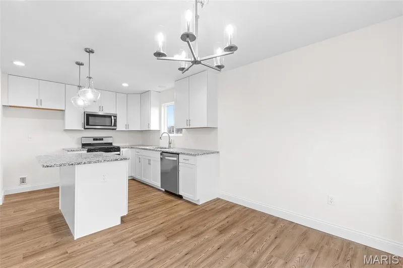 Kitchen featuring stainless steel appliances, light wood-type flooring, a center island, a chandelier, and recessed lighting — 1 TBB Sydney @ Kreder Farms, St Charles, MO 63304