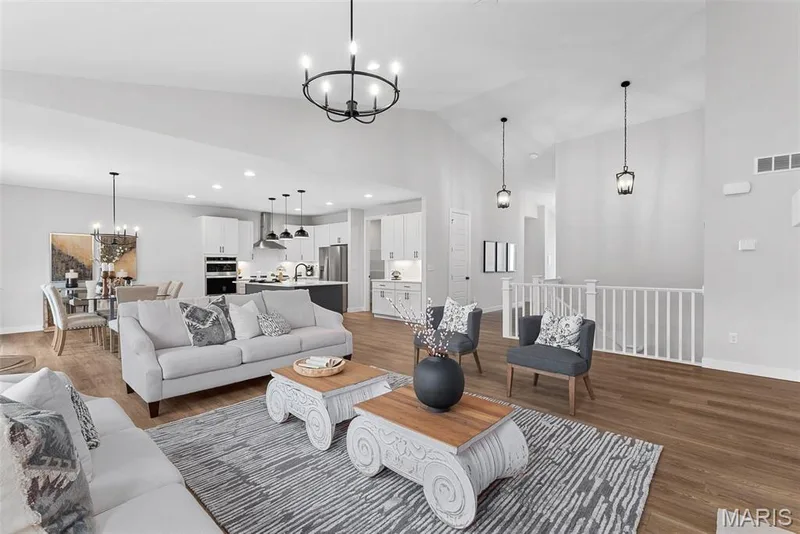 Living room with a chandelier, wood finished floors, high vaulted ceiling, and recessed lighting — Canterbury @ Providence Estates, Foristell, MO 63348
