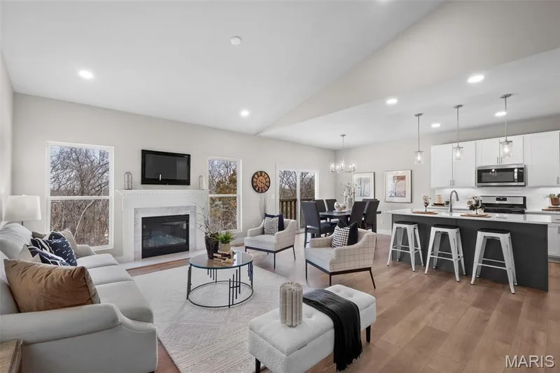 Living area with recessed lighting, lofted ceiling, light wood-type flooring, a chandelier, and a high end fireplace — 1 TBB Rockport @ Creekside Sommers, O'Fallon, MO 63367