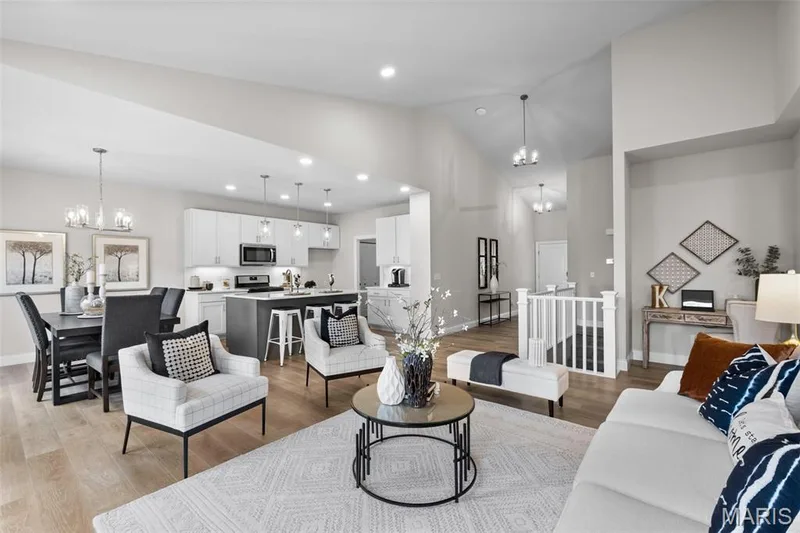 Living room featuring a chandelier, vaulted ceiling, recessed lighting, and light wood-style floors — 1 TBB Rockport @ Creekside Sommers, O'Fallon, MO 63367