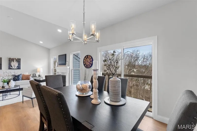 Dining space featuring light wood-type flooring, vaulted ceiling, a chandelier, a tile fireplace, and recessed lighting — 1 TBB Rockport @ Creekside Sommers, O'Fallon, MO 63367