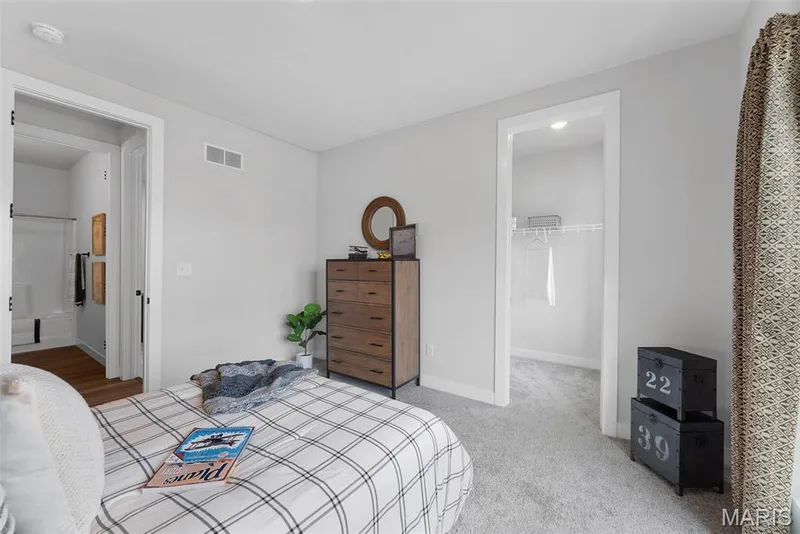 Carpeted bedroom with a walk in closet and baseboards — 1 TBB Canterbury @ Creekside Sommers, O'Fallon, MO 63367