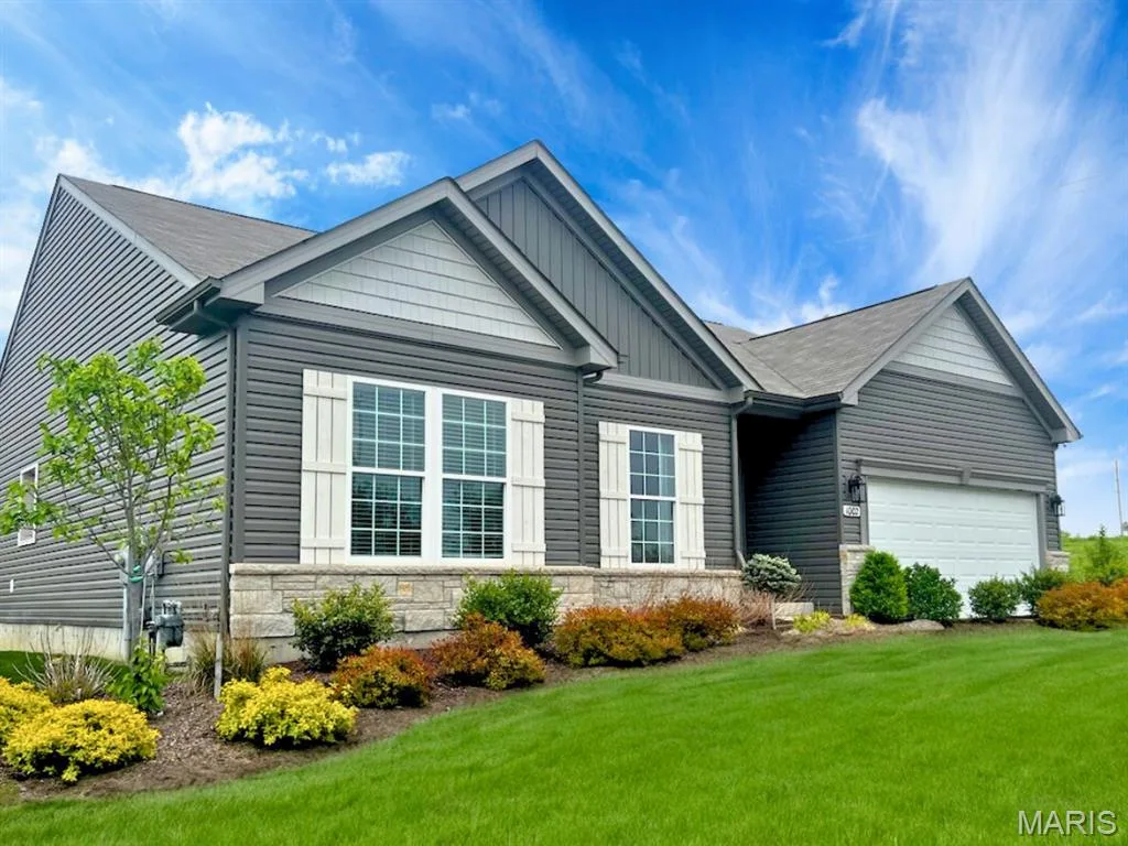 View of front facade featuring stone siding, board and batten siding, a front yard, and a garage — 1 TBB Rochester @ Creekside Sommers, O'Fallon, MO 63367