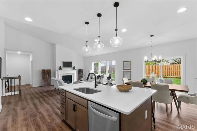 Kitchen featuring dark wood-type flooring, dishwasher, a fireplace, light stone countertops, and open floor plan — 1 TBB Rochester @ Creekside Sommers, O'Fallon, MO 63367