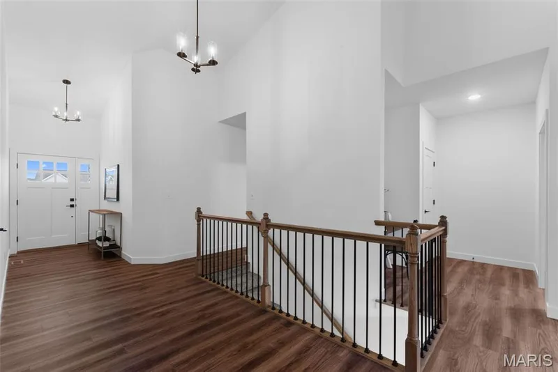 Entryway featuring a towering ceiling, dark wood-style flooring, and a chandelier — 1 TBB Rochester @ Creekside Sommers, O'Fallon, MO 63367