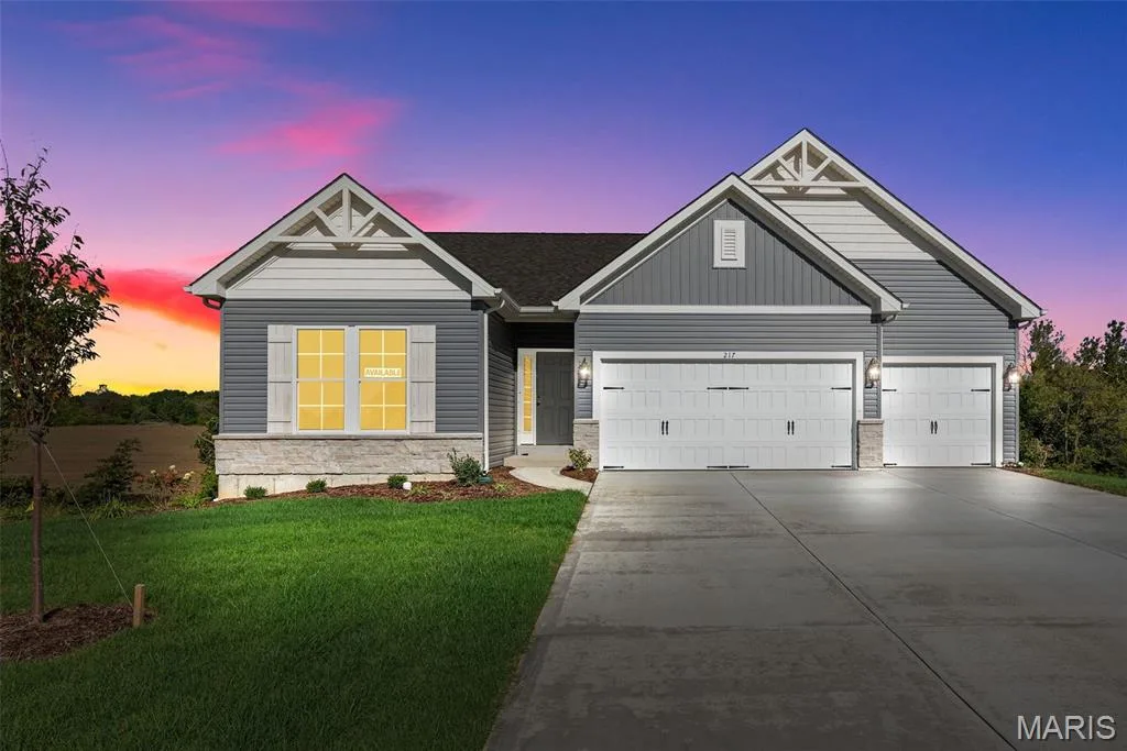 View of front of house with stone siding, driveway, a yard, and an attached garage — 1 TBB Westbrook @ Creekside Sommers, O'Fallon, MO 63367
